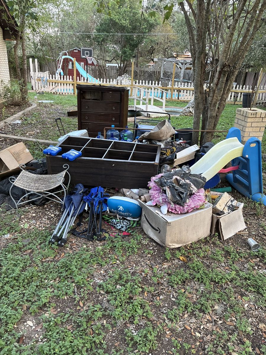 Backyard junk pile before pickup in Kyle, TX